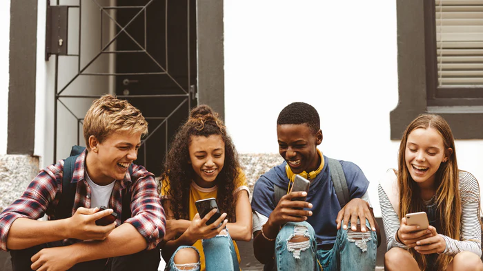 Teenagers looking down at mobile phones